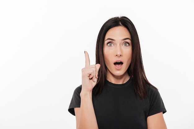 Portrait of an excited woman poiting finger up