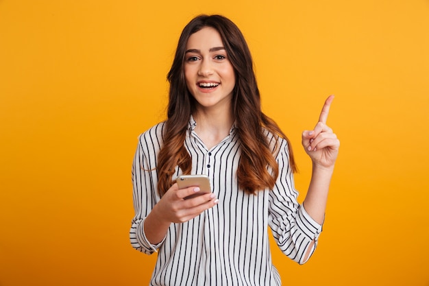 Portrait of an excited young girl holding mobile phone