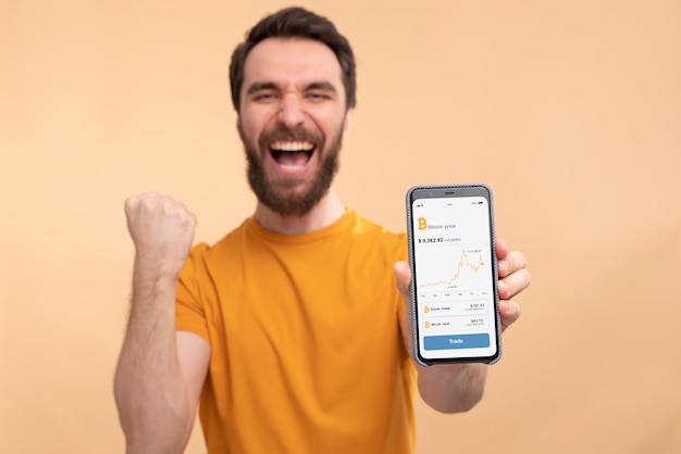 Free photo portrait of an excited young man showing his smartphone