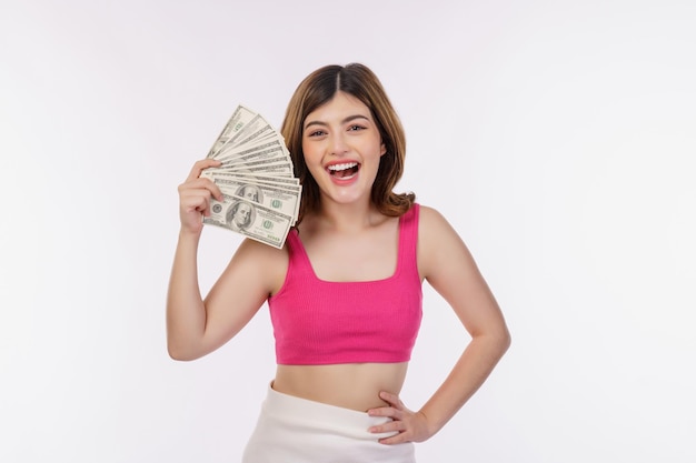 Portrait of excited young woman holding bunch of dollars banknotes isolated over white background