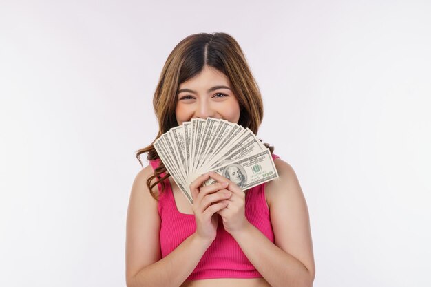 흰색 배경에 고립 된 달러 지폐의 무리를 들고 흥분된 젊은 여자의 초상화