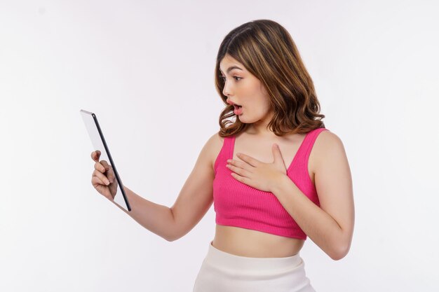 Portrait of excited young woman holding tablet isolated over white background