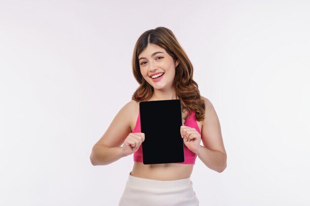 Portrait of excited young woman holding tablet mock up isolated over white background