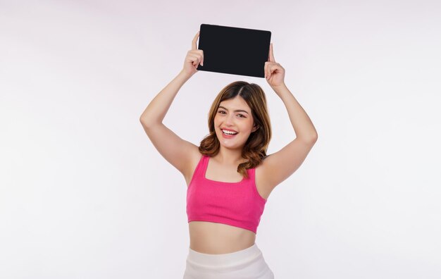 Portrait of excited young woman holding tablet mock up isolated over white background