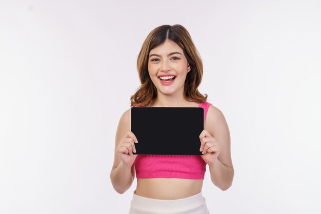 Portrait of excited young woman holding tablet mock up isolated over white background