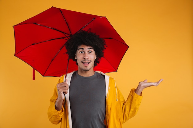 Portrait of an exciting afro american man dressed in raincoat