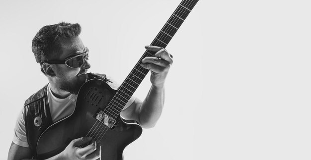 Portrait of expressive man rock musician playing guitar Black and white photography