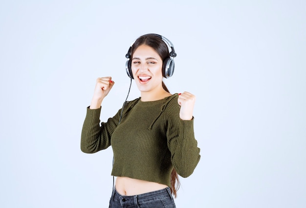 Portrait of expressive young girl listening to music and dancing.