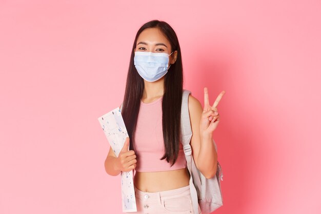 Portrait expressive young woman holding map and wearing mask