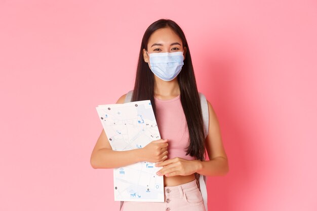 Portrait expressive young woman holding map and wearing mask