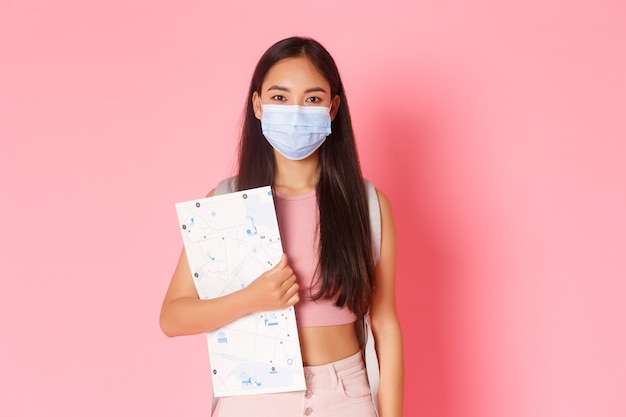 Portrait expressive young woman holding map and wearing mask