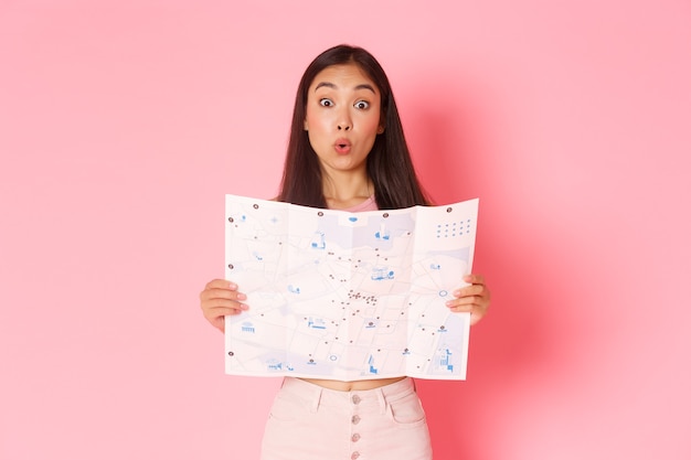 Portrait expressive young woman holding map