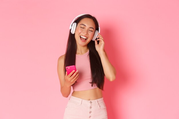 Портрет выразительной молодой женщины с наушниками, слушающей музыку