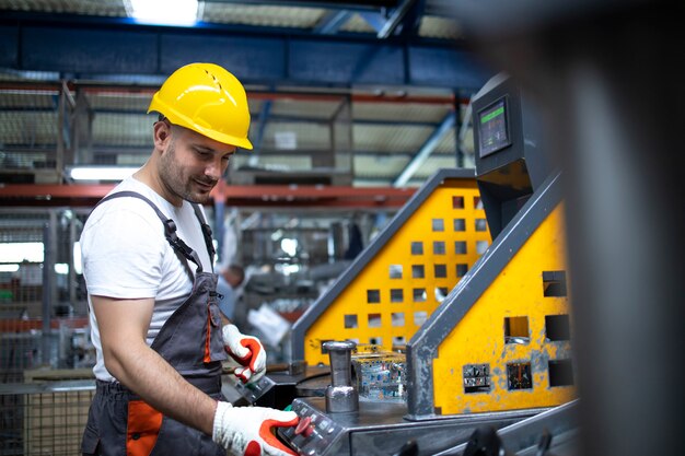 Portrait of factory worker working on industrial machine in production plant