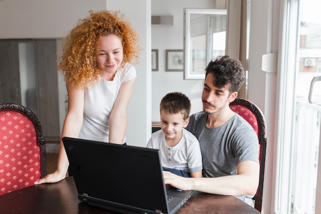 Portrait of family looking at laptop over table