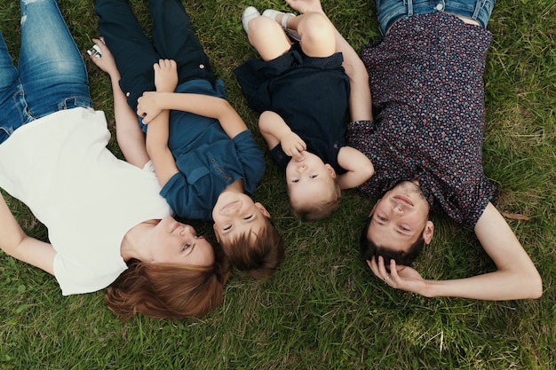 Portrait family with kids lying on the grass