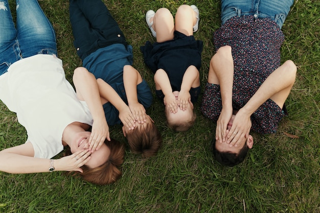 草の上に横たわる子供と家族の肖像画