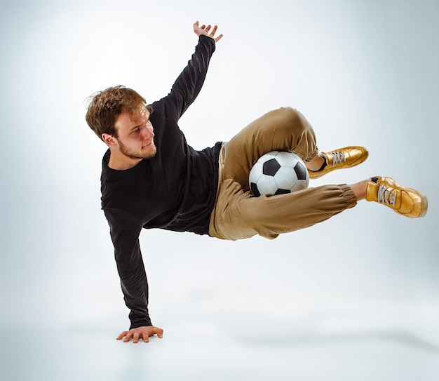 A portrait of a fan with ball on gray studio background. Freestile