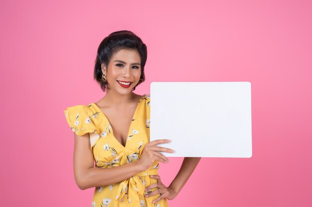 Portrait of fashion woman displaying white banner