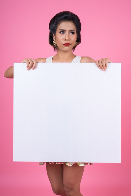 Portrait of fashion woman displaying white banner