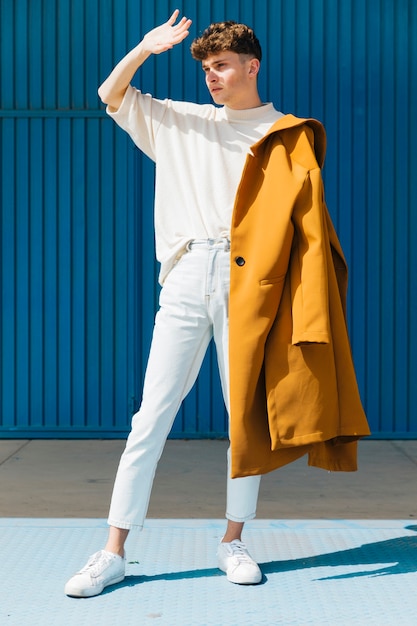 Portrait of fashionable boy against blue wall