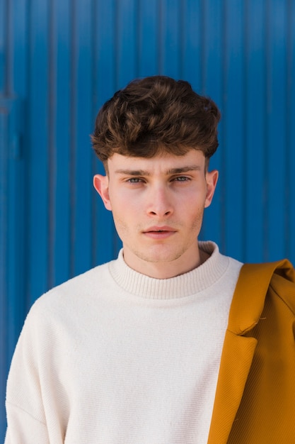 Portrait of fashionable boy against blue wall