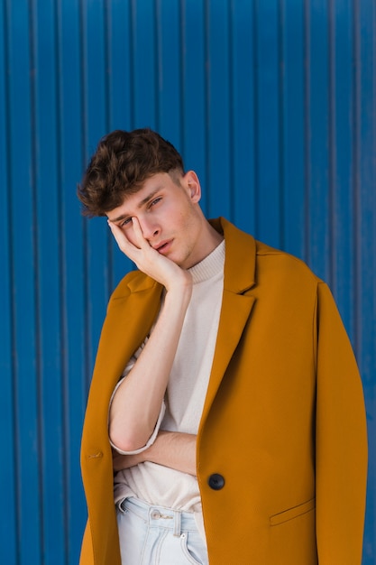 Portrait of fashionable boy against blue wall