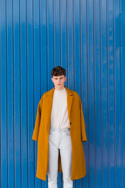 Portrait of fashionable boy against blue wall
