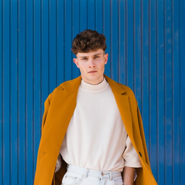 Portrait of fashionable boy against blue wall