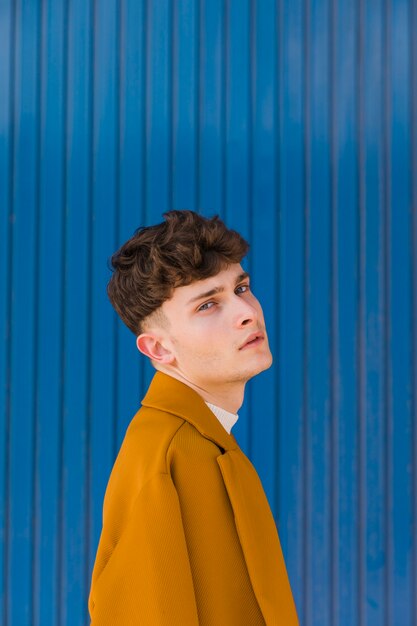 Portrait of fashionable boy against blue wall