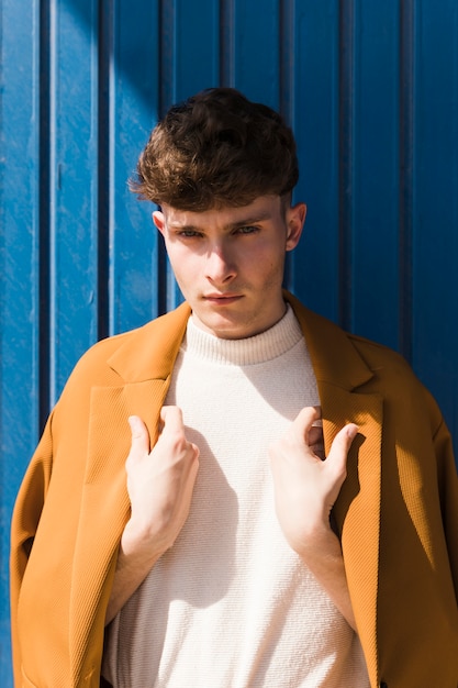 Portrait of fashionable boy against blue wall