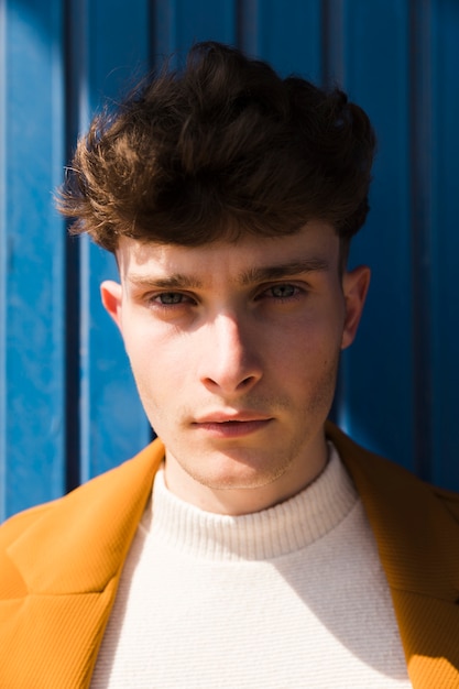 Portrait of fashionable boy against blue wall