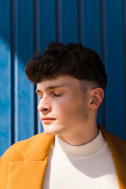 Portrait of fashionable boy against blue wall