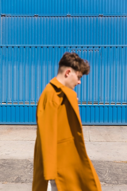 Portrait of fashionable boy against blue wall