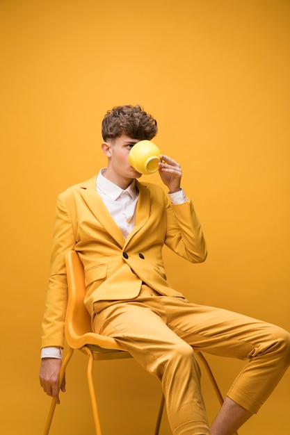 Portrait of fashionable boy drinking from a cup