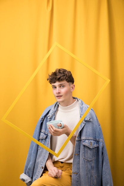 Portrait of fashionable boy drinking within a frame