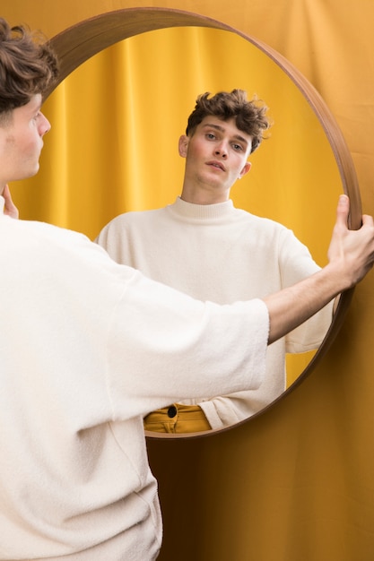 Portrait of fashionable boy in front of mirror