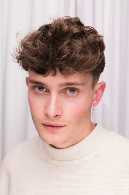 Free photo portrait of fashionable boy in front of white curtain