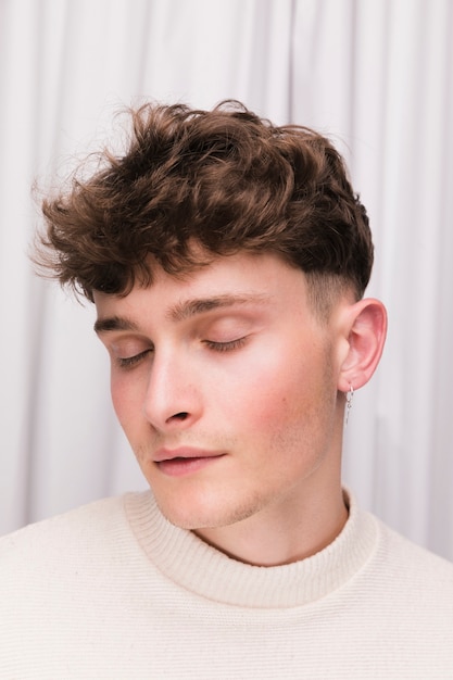 Free photo portrait of fashionable boy in front of white curtain