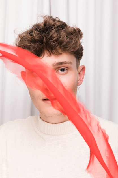 Free photo portrait of fashionable boy in front of white curtain