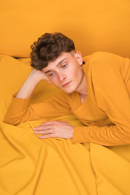 Free photo portrait of fashionable boy relaxing in bed