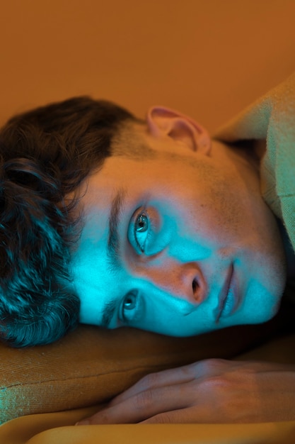 Free photo portrait of fashionable boy relaxing in bed