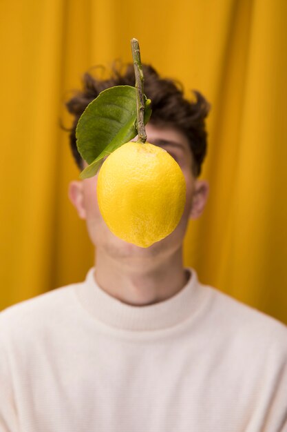 Portrait of fashionable boy with lemon