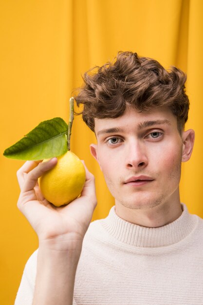 Portrait of fashionable boy with lemon