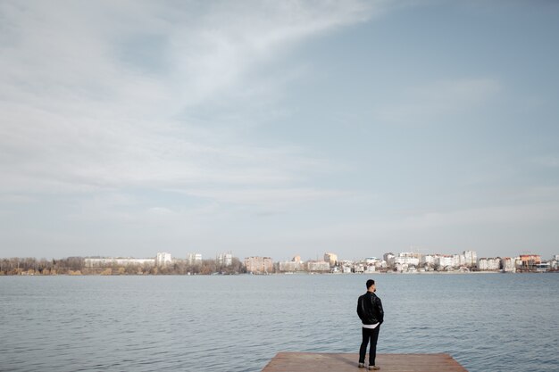 Portrait of fashionable well dressed man with beard posing outdoors