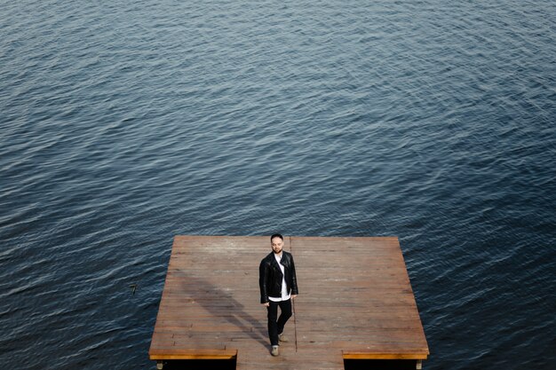 Portrait of fashionable well dressed man with beard posing outdoors