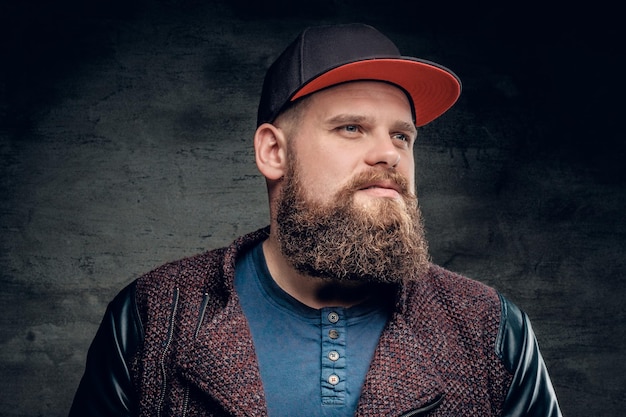 Portrait of fat bearded male dressed in a jacket and baseball cap.