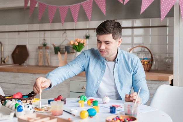 Portrait of father painting eggs for easter