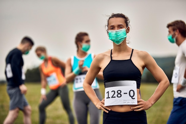 Portrait of female athlete wearing face mask while taking a part in marathon race during COVID19 pandemic