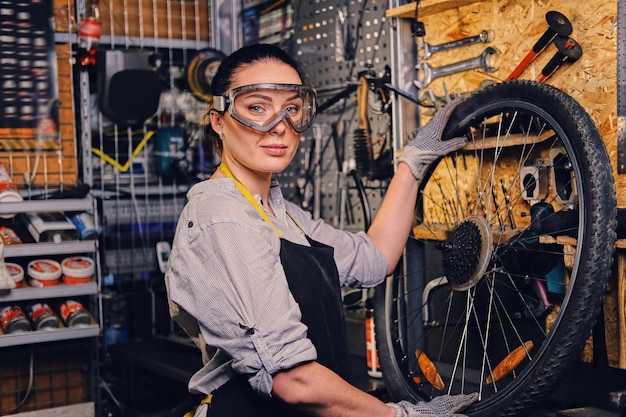 ツールスタンドの背景上の女性の自転車整備士の肖像画。